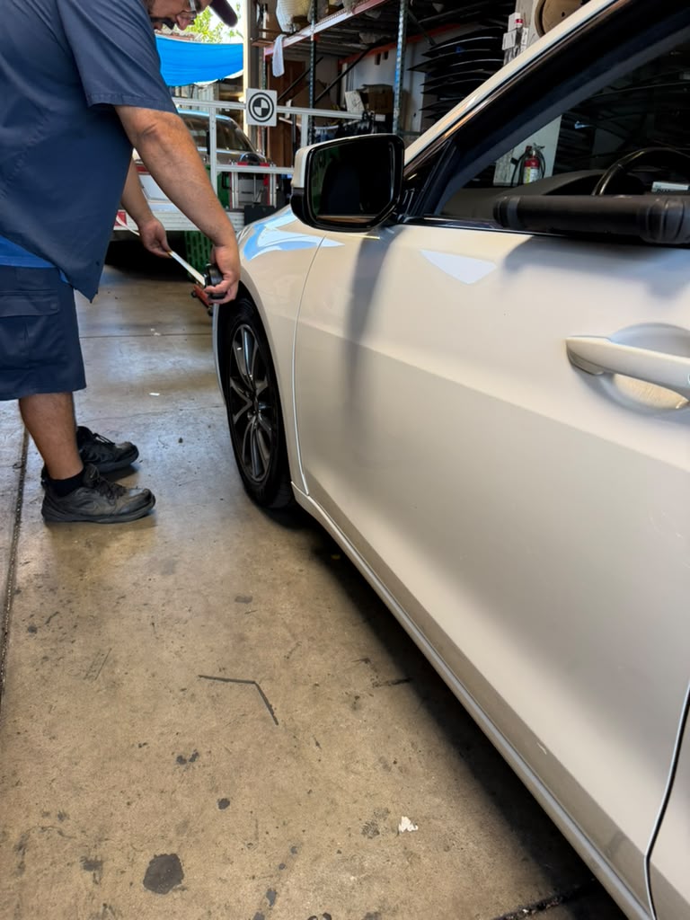 Technician aligning side mirror reference